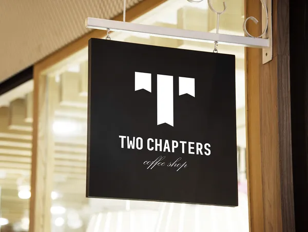 Two Chapters coffee shop hanging sign with black background and white bookmark logo design